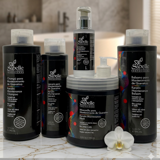 Collection of Sabelle hair care products on a marble surface with an orchid flower.